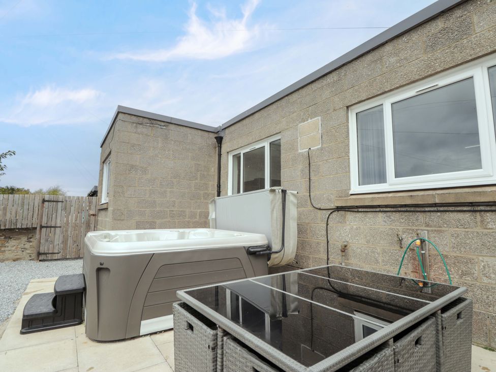 An outdoor area with a hot tub and table at Crannoch Self Catering, Cullen