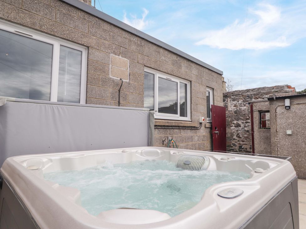 A hot tub and stone wall at Crannoch Self Catering in Cullen