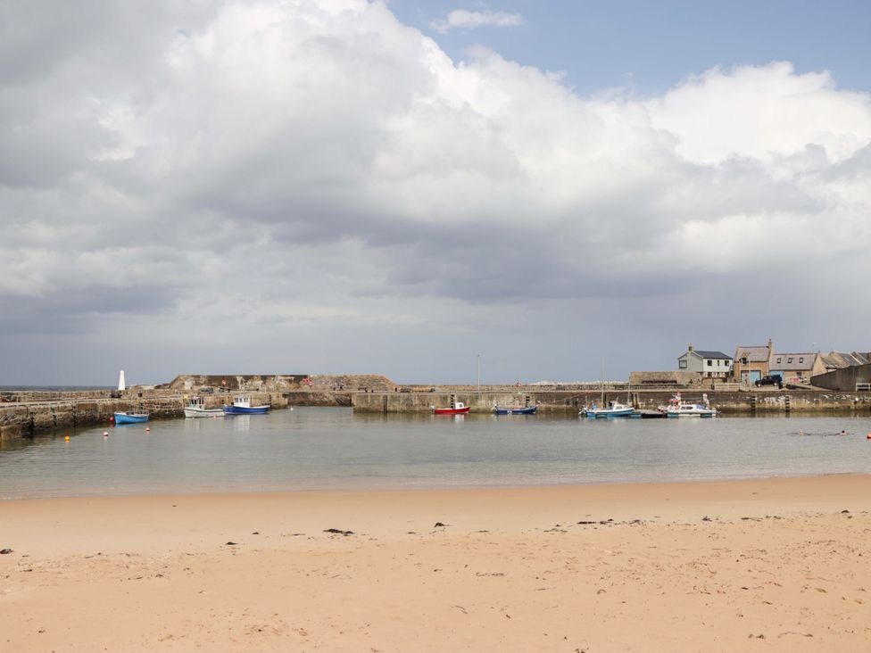 A beach area with boats in water at Crannoch Self Catering in Cullen