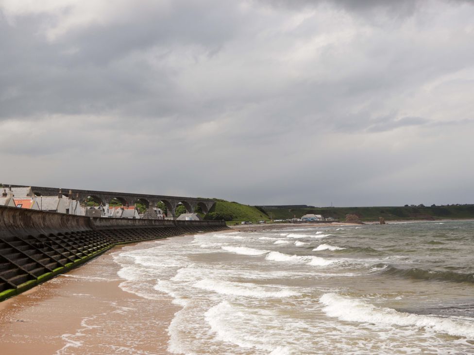 A beach scene with waves and a bridge at Crannoch Self Catering in Cullen