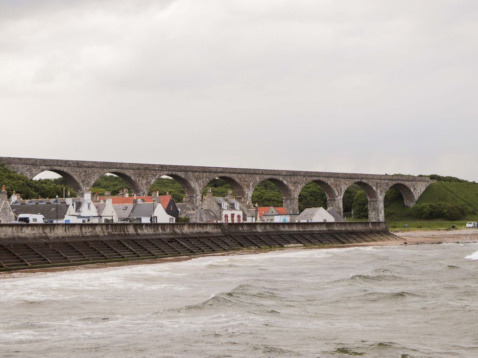 A bridge with arches above houses near a river at Crannoch Self Catering in Cullen