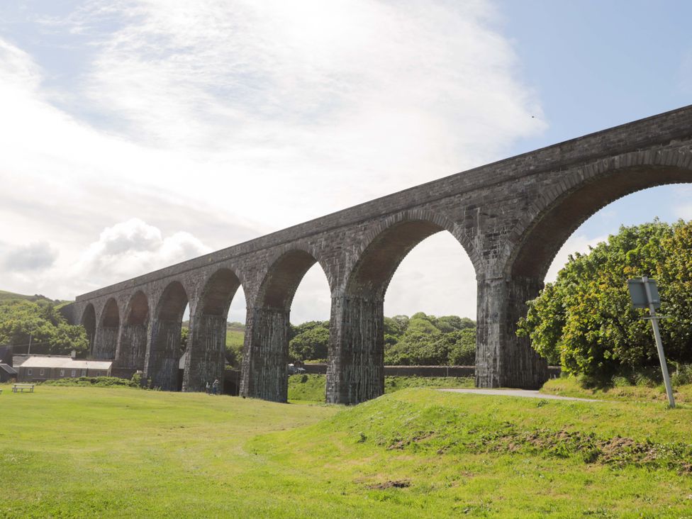 A viaduct over grass with buildings in the background at Crannoch Self Catering in Cullen