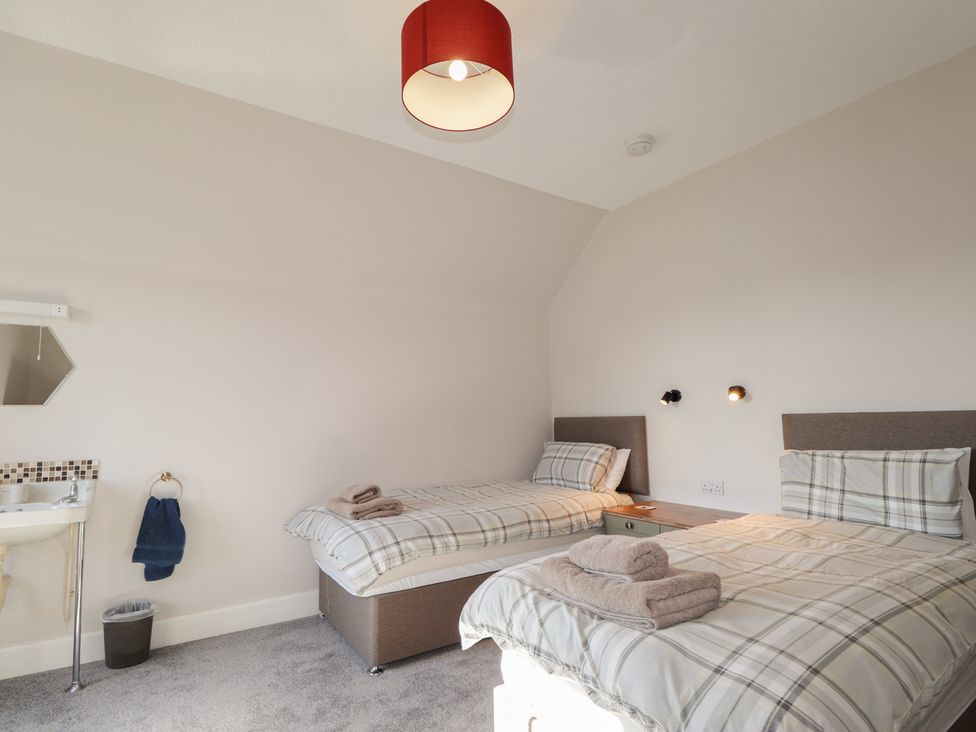 A bedroom with two beds and a sink at Crannoch Self Catering in Cullen