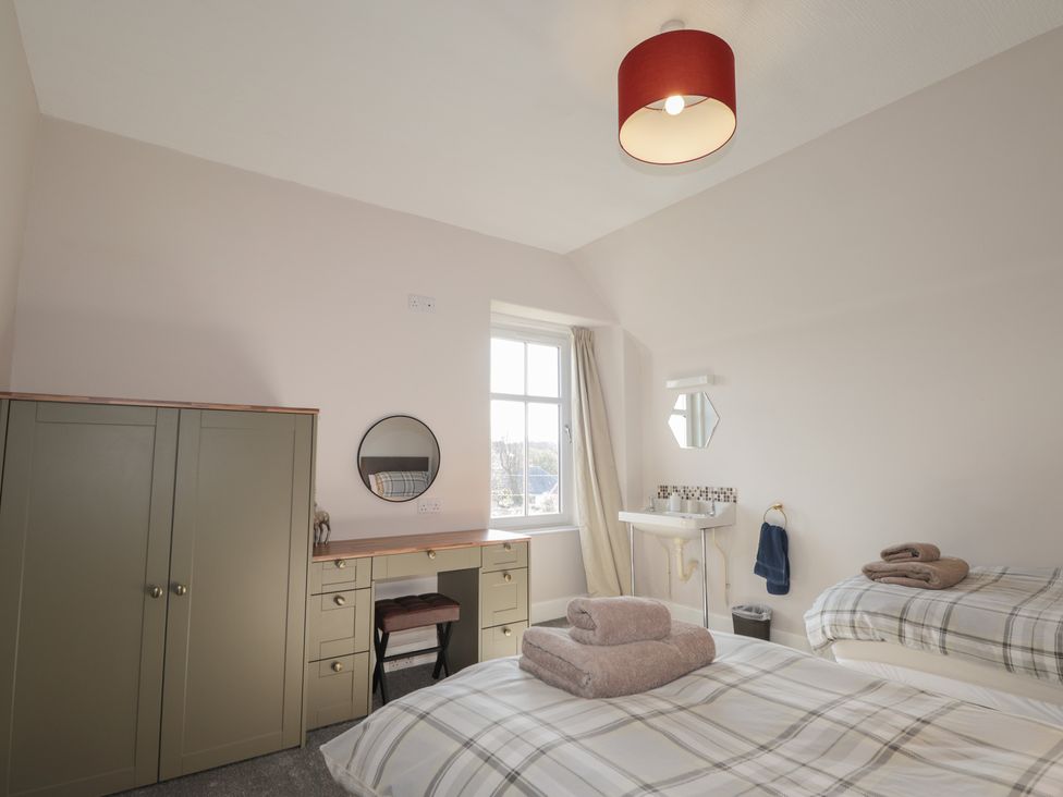 A bedroom with a bed, desk, and cabinet at Crannoch Self Catering in Cullen