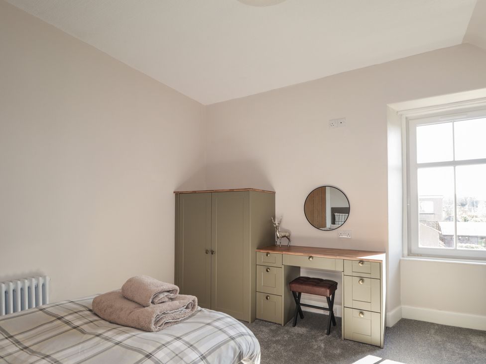 A bedroom with a bed and desk at Crannoch Self Catering in Cullen