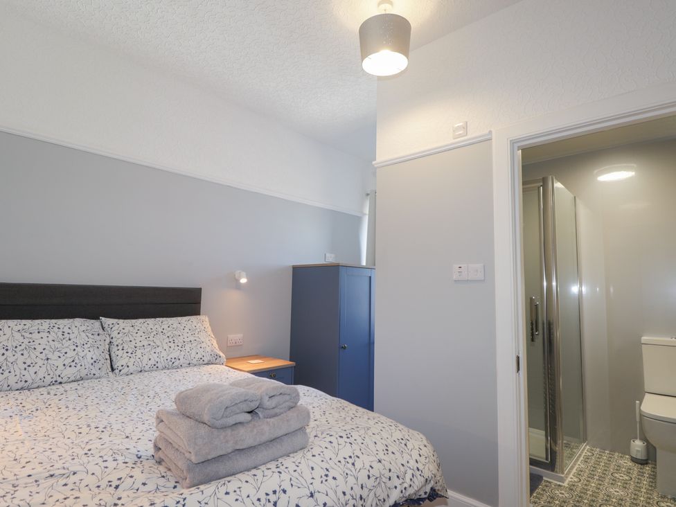 A bedroom with a bed and an en-suite bathroom at Crannoch Self Catering in Cullen