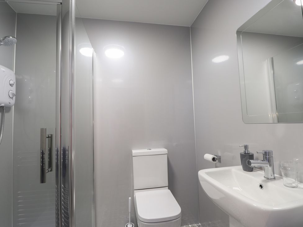 A bathroom with a shower, toilet, and sink at Crannoch Self Catering in Cullen