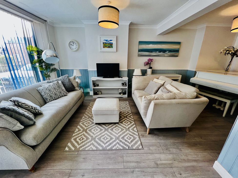 A living room with a sofa and TV at 51 North Street in Wareham
