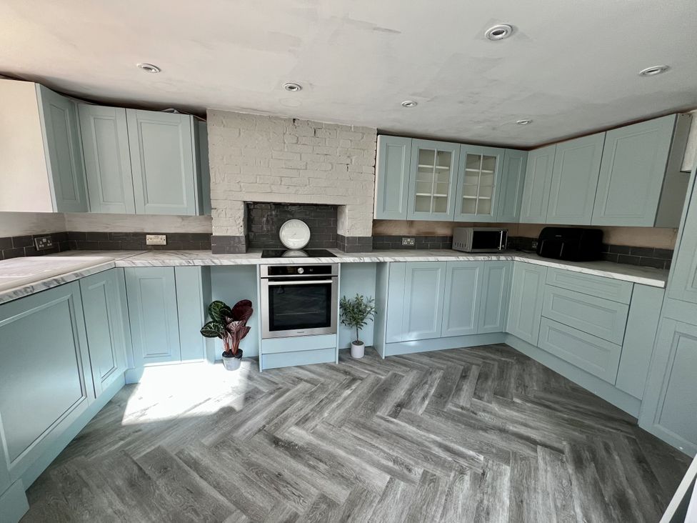 A kitchen with blue cabinets and appliances at 51 North Street in Wareham