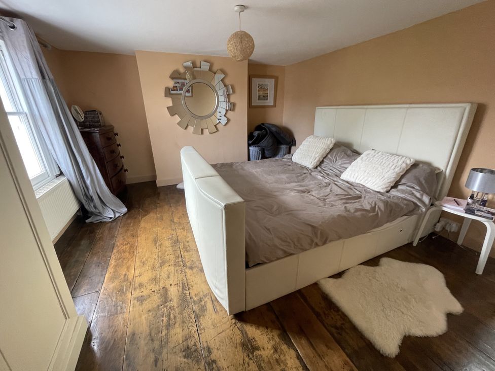 A bedroom with a bed and a mirror at 51 North Street Wareham