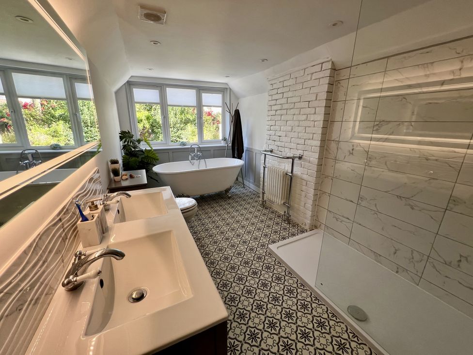 A bathroom with a bathtub and dual sinks at 51 North Street Wareham