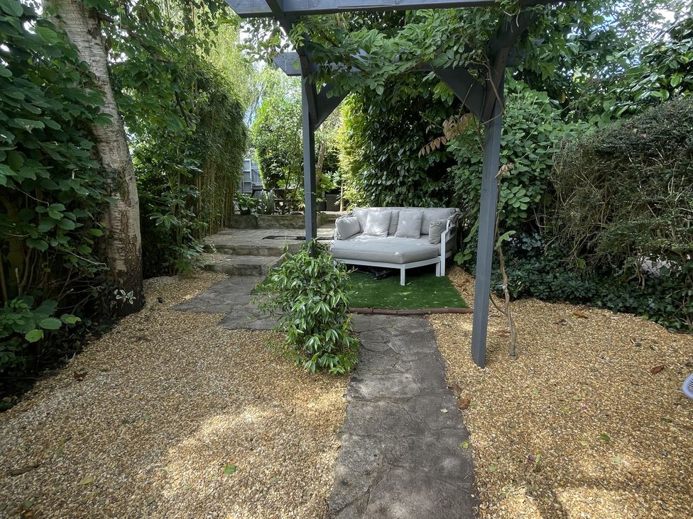 A garden with a sofa and a pathway at 51 North Street Wareham