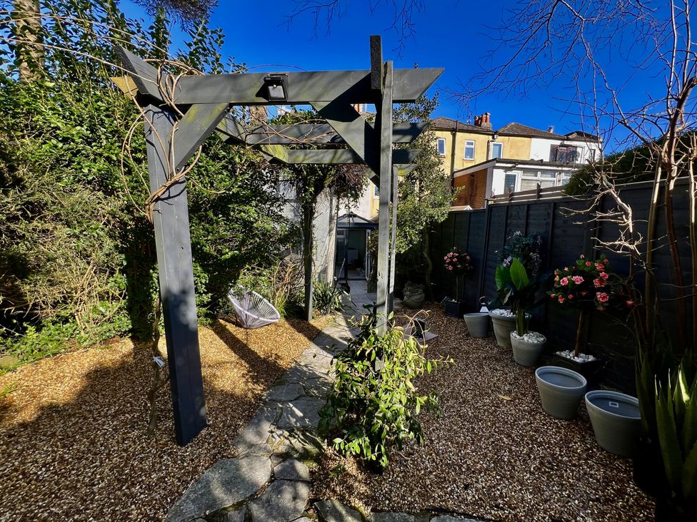 A garden with a trellis and planters at 51 North Street Wareham