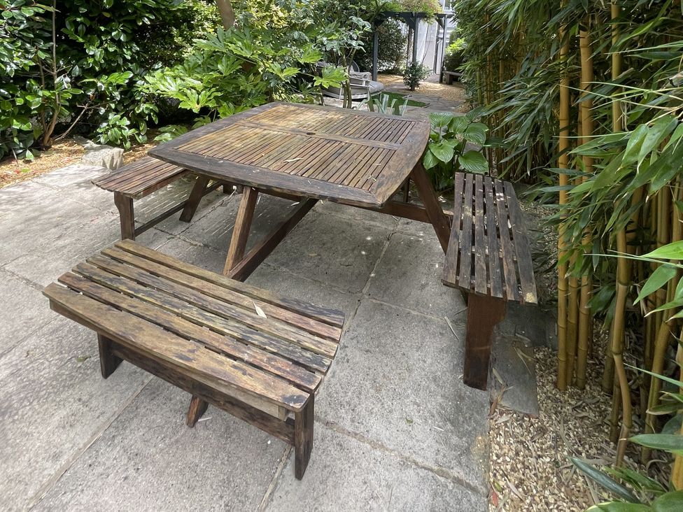A garden with a wooden table and benches at 51 North Street in Wareham