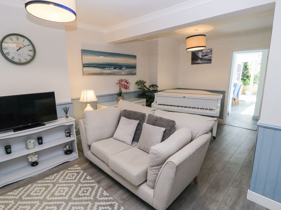 A living room with a sofa and piano at Delightful Dorset House By Wareham River in Wareham