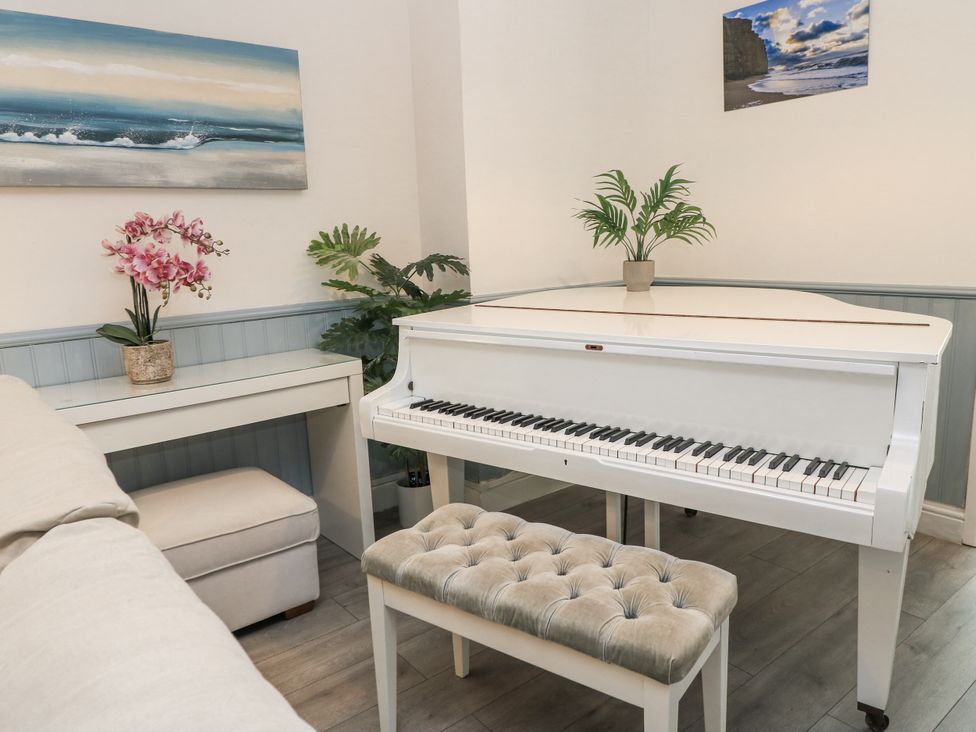 A living room with a piano and seating at Delightful Dorset House By Wareham River in Wareham