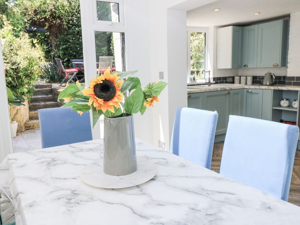 A dining room with a marble table and flower vase at Delightful Dorset House By Wareham River Wareham