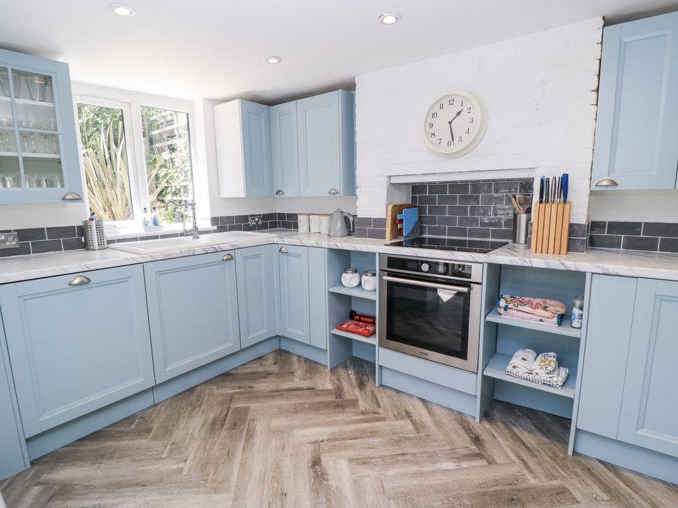 A kitchen with cabinets, sink, oven, and window at Delightful Dorset House By Wareham River, Wareham