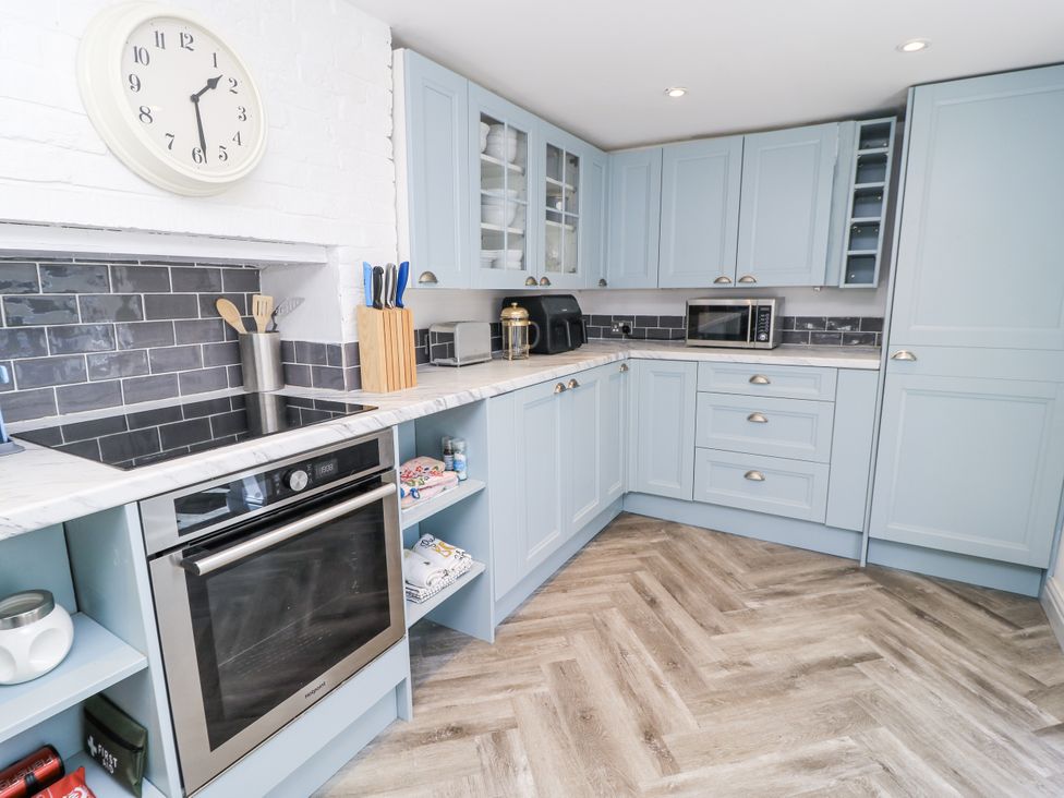 A kitchen with cabinets, an oven, and a microwave at Delightful Dorset House By Wareham River in Wareham