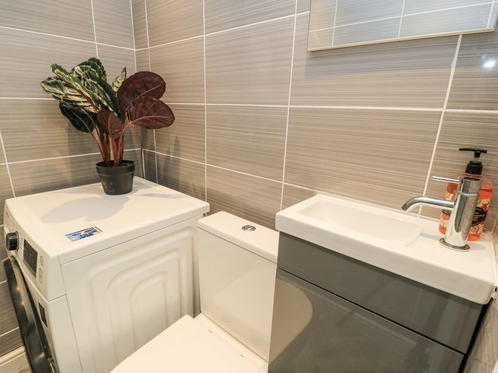 A bathroom with a washing machine, toilet, and sink at Delightful Dorset House By Wareham River, Wareham