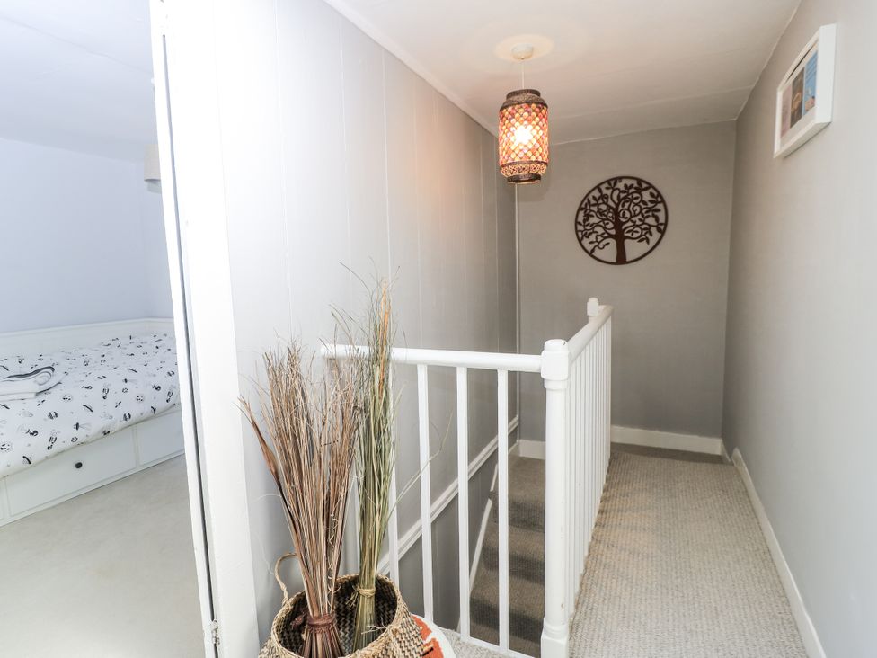 A hallway with a staircase and decorative wall art at Delightful Dorset House By Wareham River in Wareham