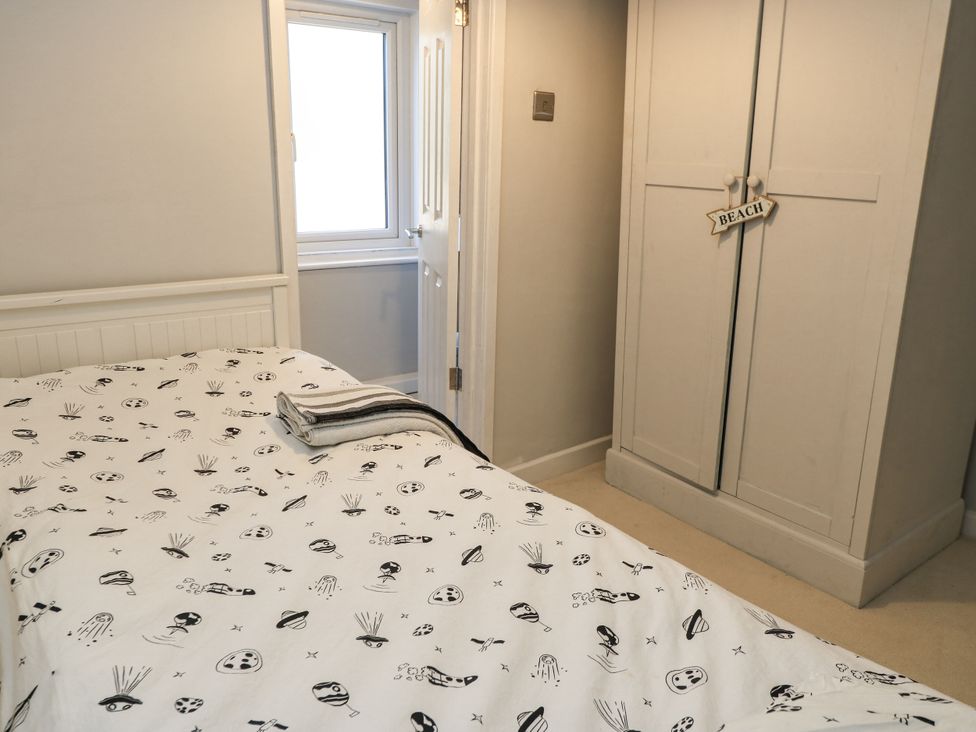 A bedroom with a bed and wardrobe at Delightful Dorset House By Wareham River, Wareham