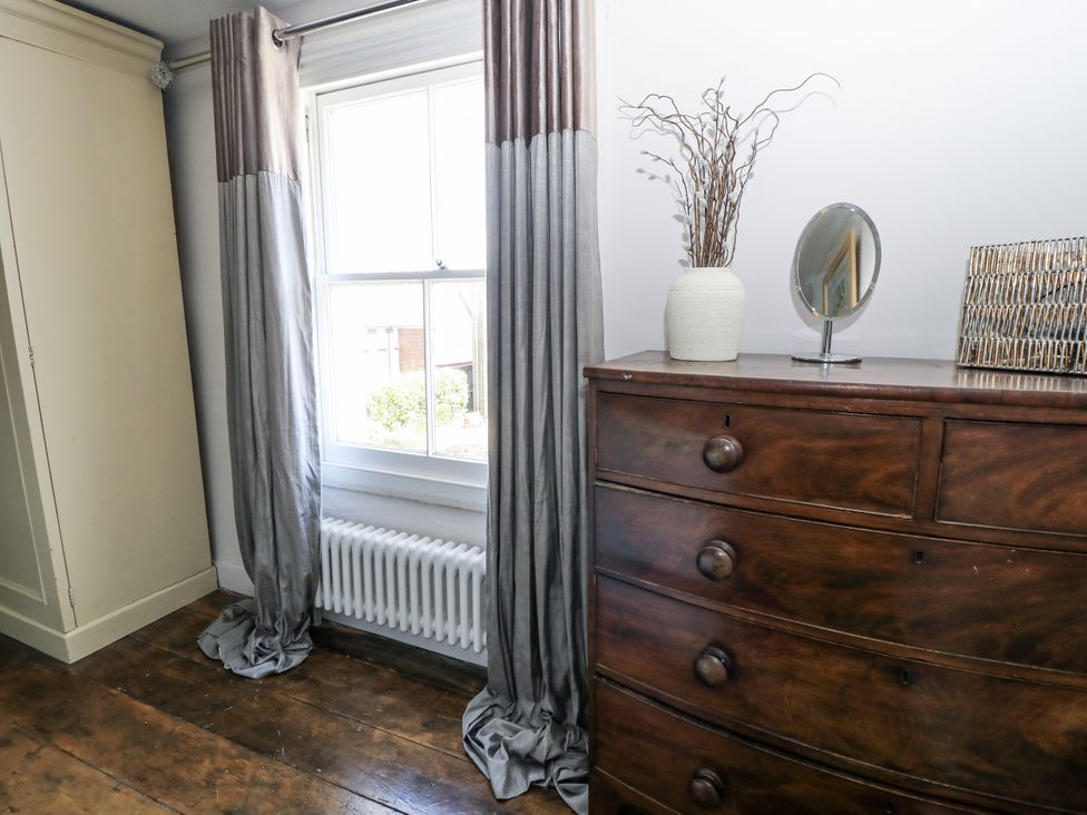 A bedroom with curtains and a dresser at Delightful Dorset House By Wareham River, Wareham