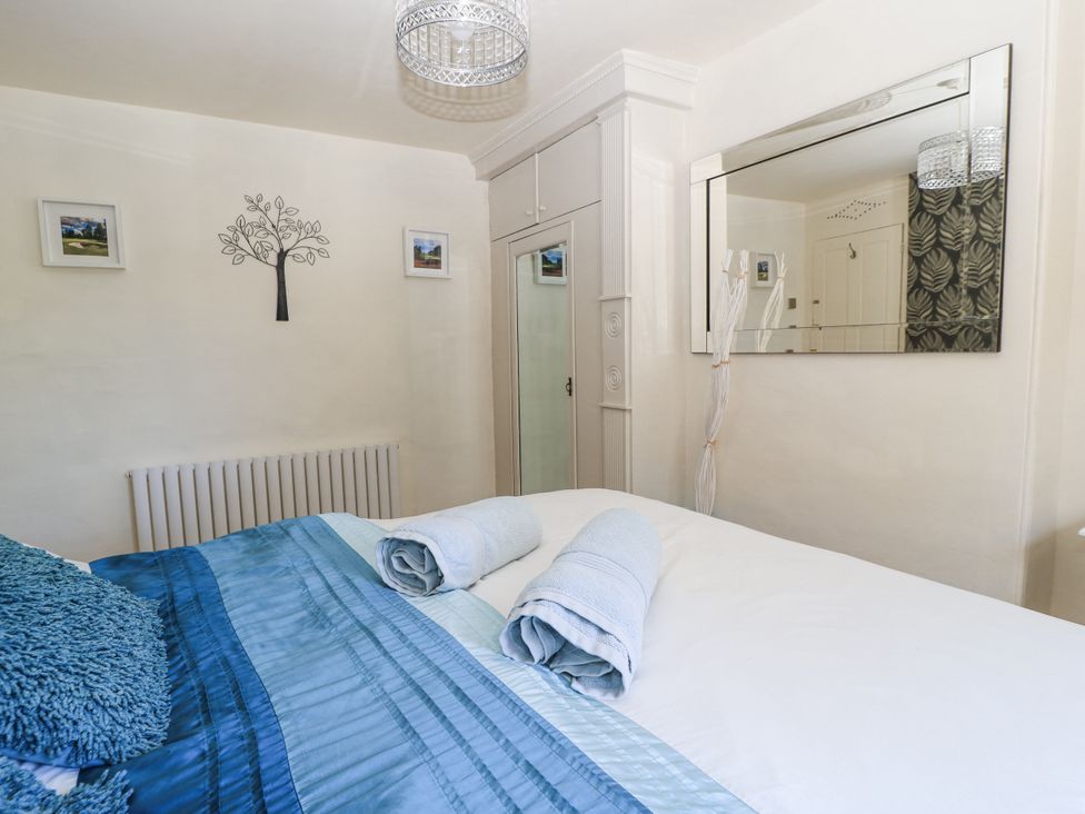 A bedroom with a bed and towels at Delightful Dorset House By Wareham River in Wareham