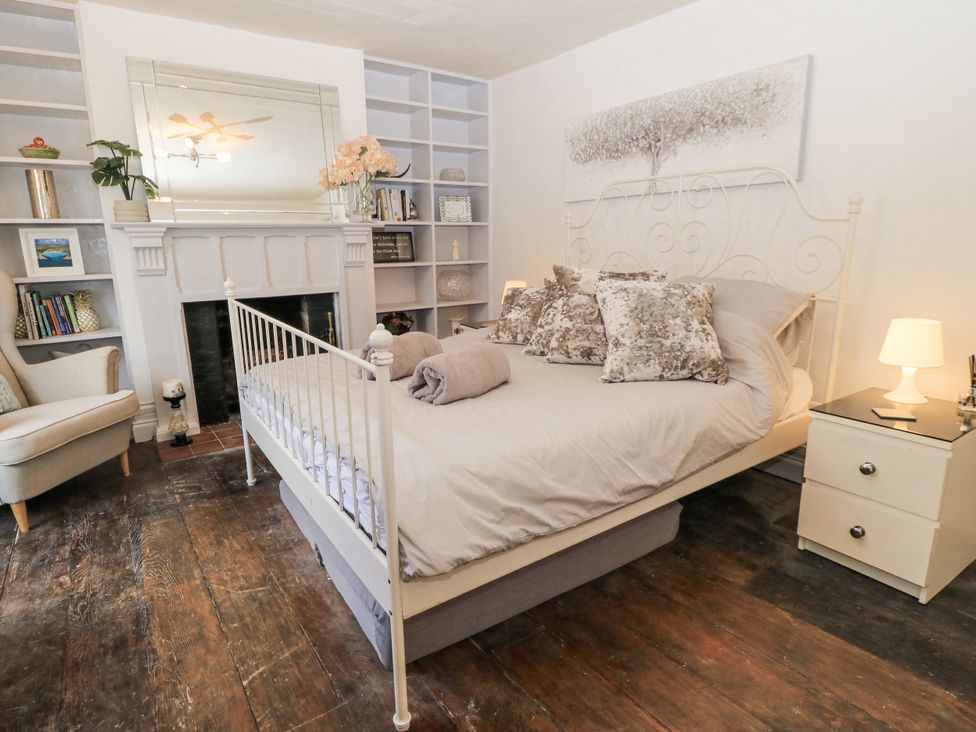 A bedroom with a bed and bookshelf at Delightful Dorset House By Wareham River in Wareham