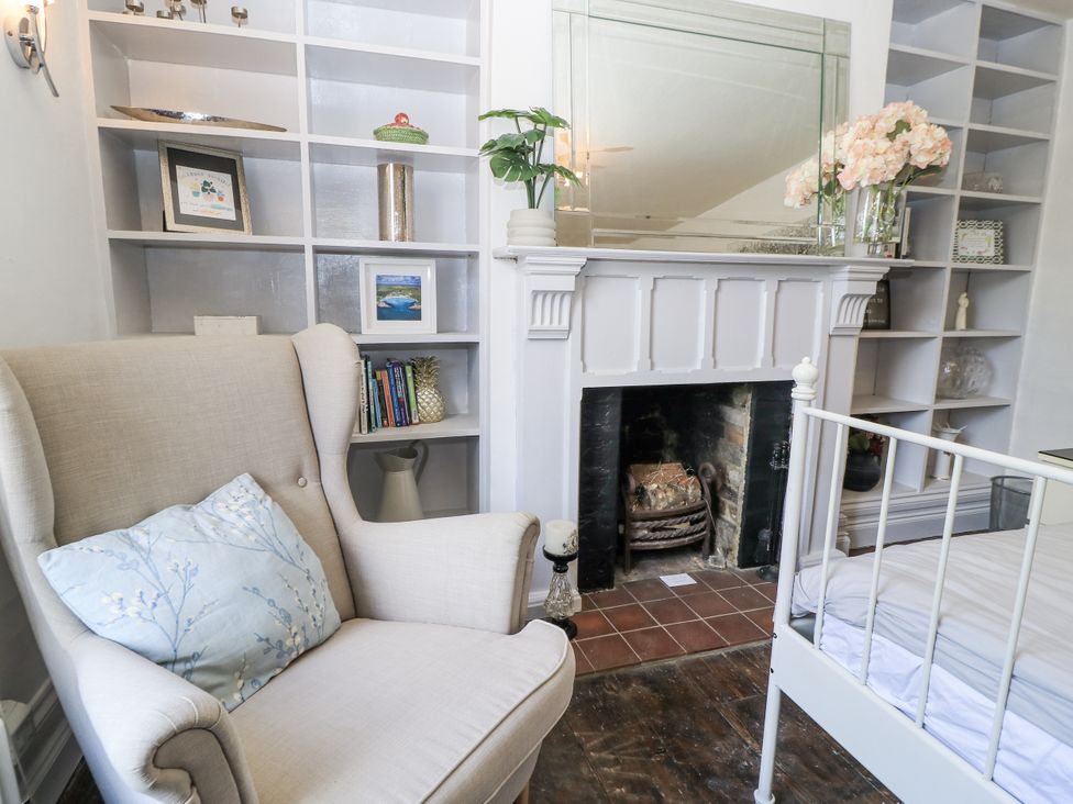 A living room with an armchair and a fireplace at Delightful Dorset House By Wareham River, Wareham