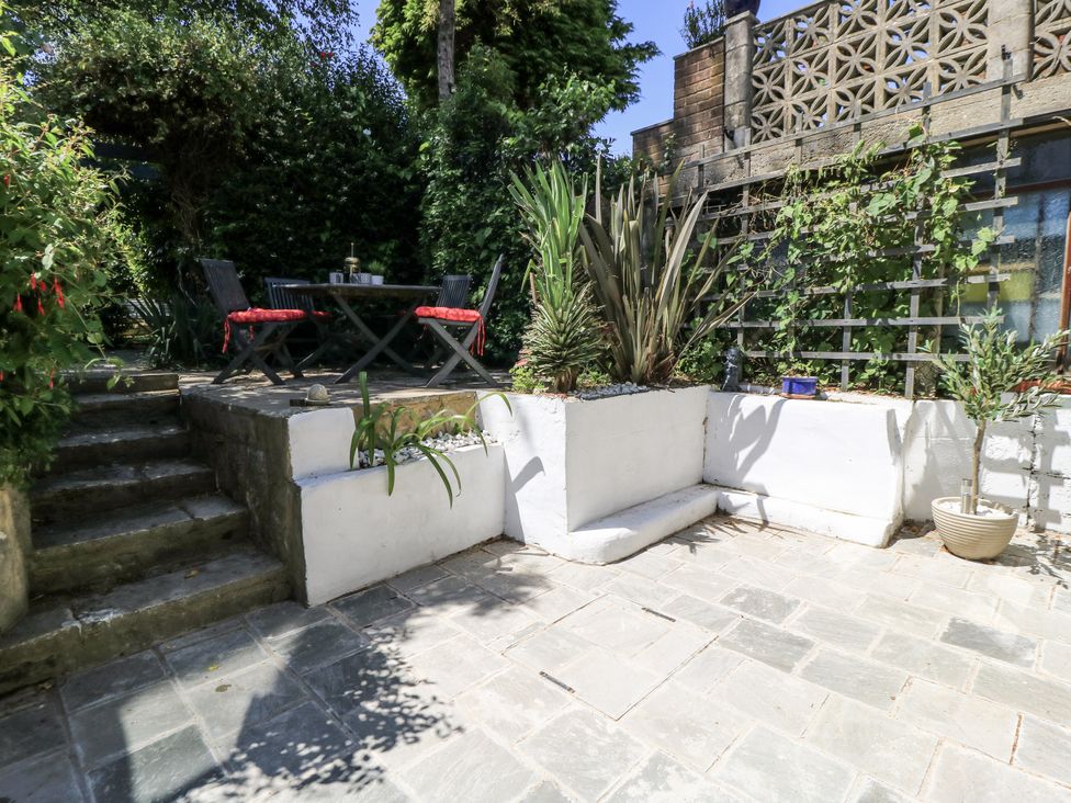 A garden with a table and chairs at Delightful Dorset House By Wareham River in Wareham