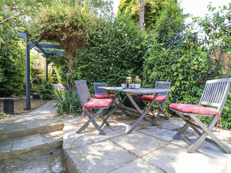 A garden with a table and chairs at Delightful Dorset House By Wareham River in Wareham