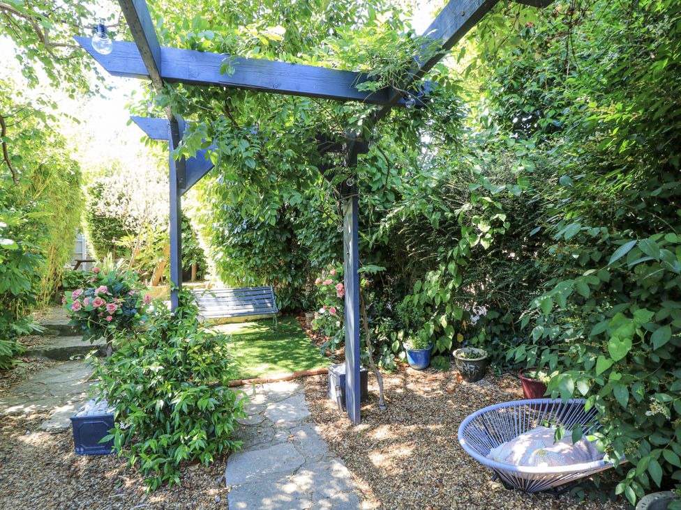 A garden with a swing and various plants at Delightful Dorset House By Wareham River in Wareham