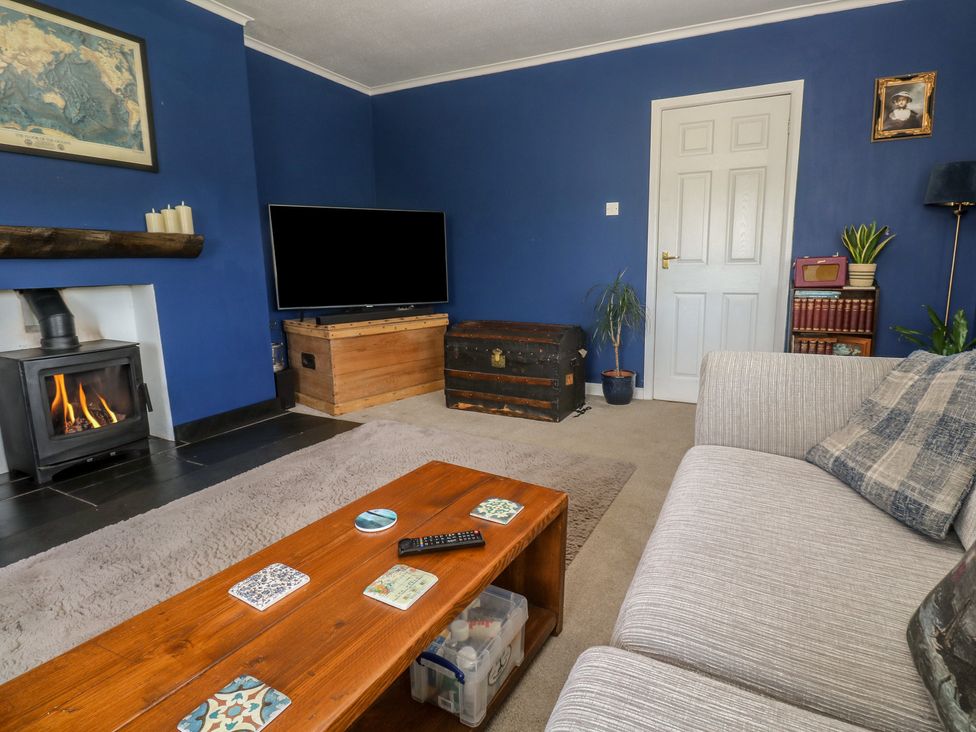 A living room with a fireplace and a television at 4 Cardell Way in Newquay