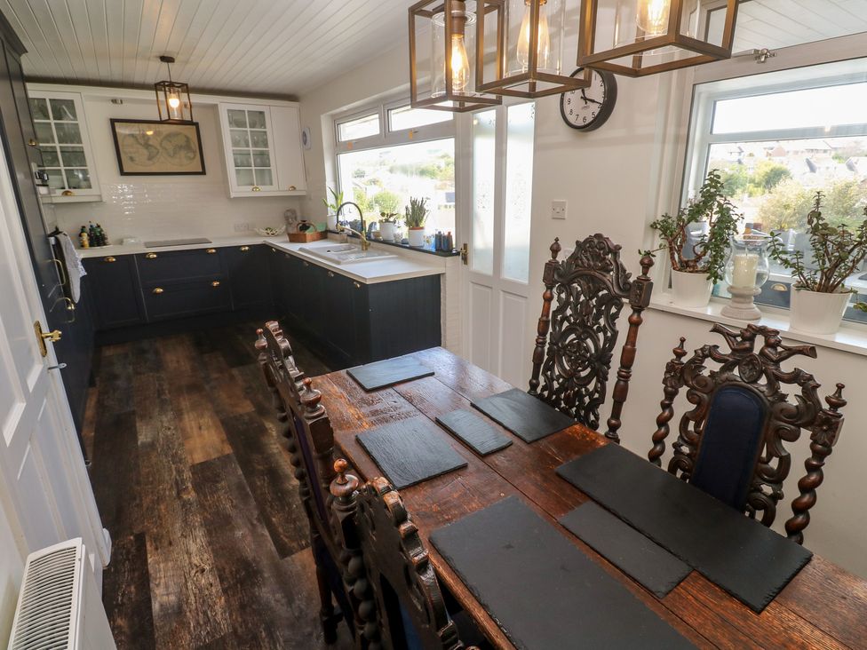 A kitchen with a dining table and chairs at 4 Cardell Way in Newquay