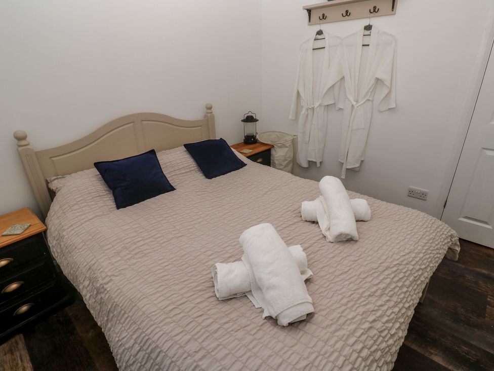 A bedroom with a bed and towels at 4 Cardell Way in Newquay