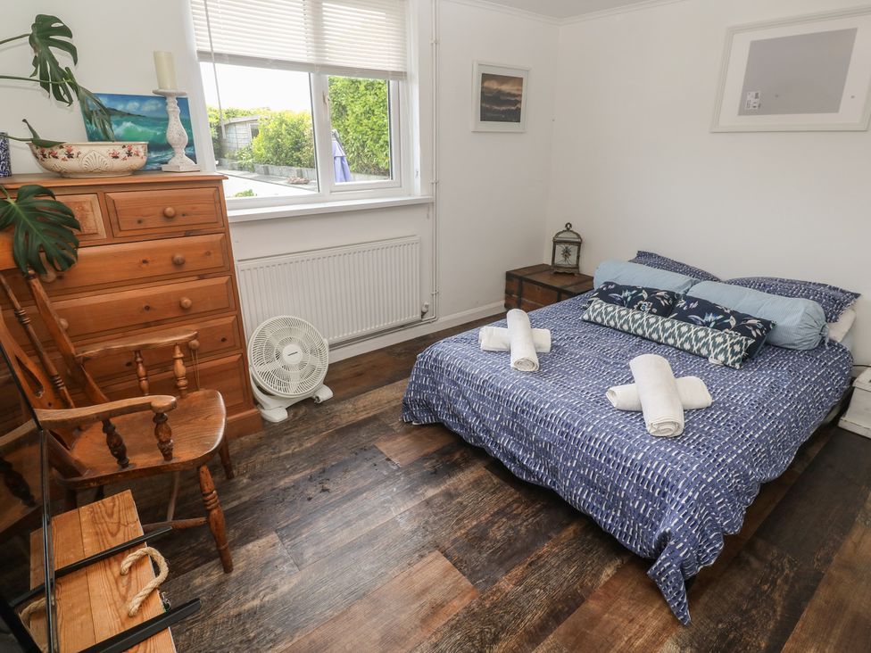 A bedroom with a bed and dresser at 4 Cardell Way in Newquay