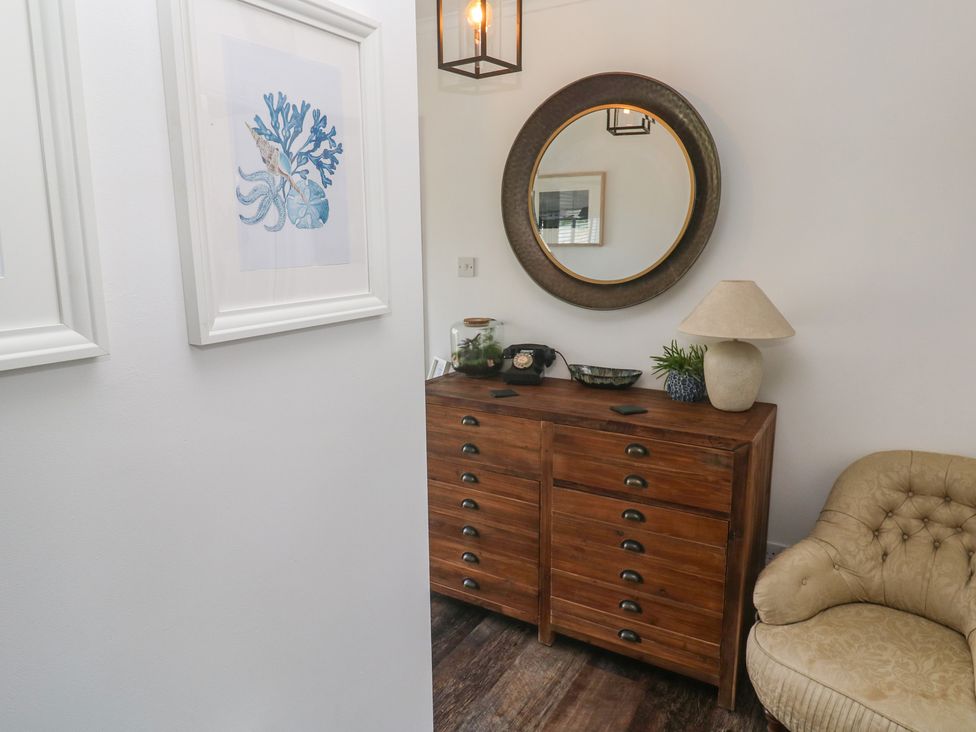 An entryway with a cabinet and mirror at 4 Cardell Way in Newquay