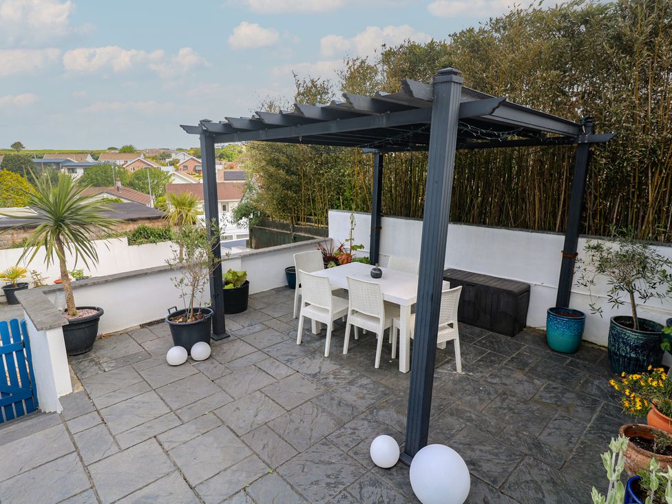 A garden with a pergola and dining set at 4 Cardell Way in Newquay