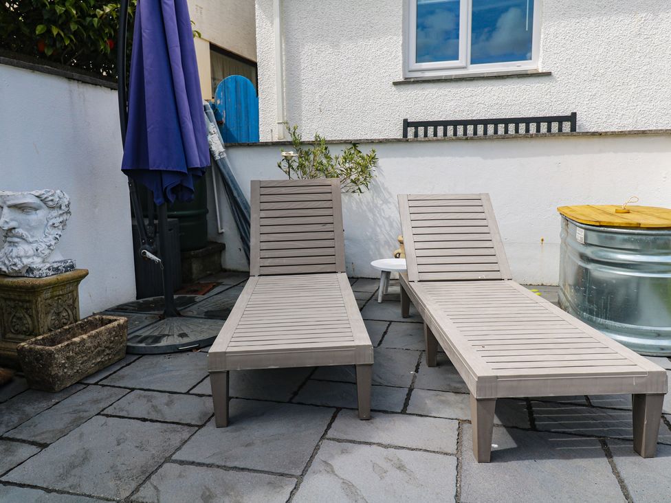 Two lounge chairs and a patio umbrella in an outdoor area at 4 Cardell Way Newquay