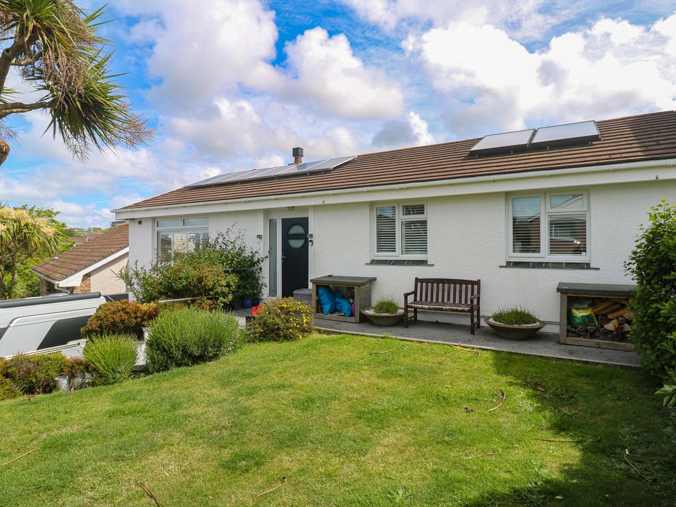 A house with solar panels and a bench in the front yard at 4 Cardell Way Newquay