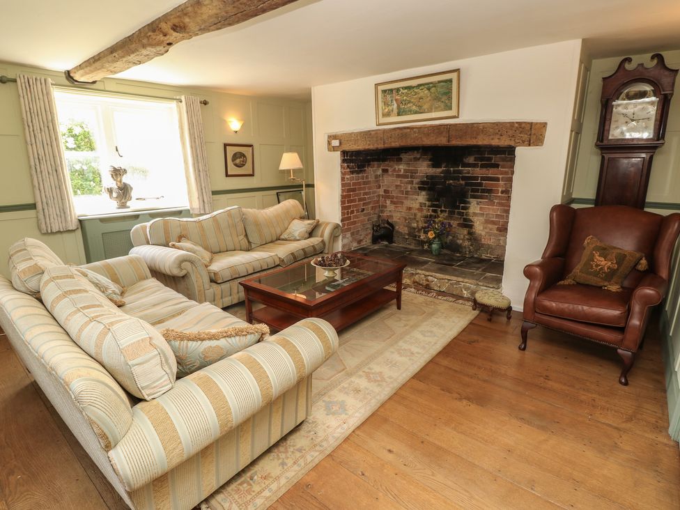 A living room with sofas and a fireplace at Guildford Farmhouse in Ryde