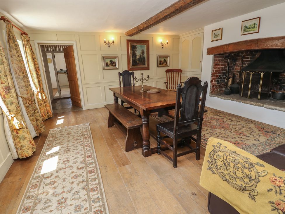 A dining room with a wooden table and chairs at Guildford Farmhouse in Ryde