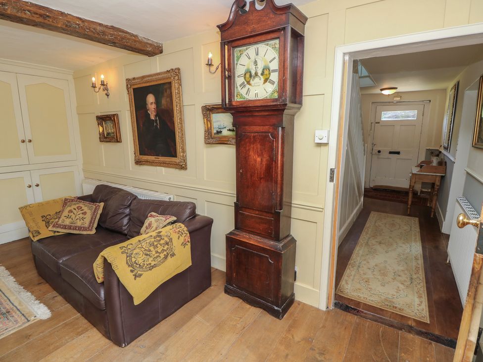A living room with a clock and sofa at Guildford Farmhouse in Ryde