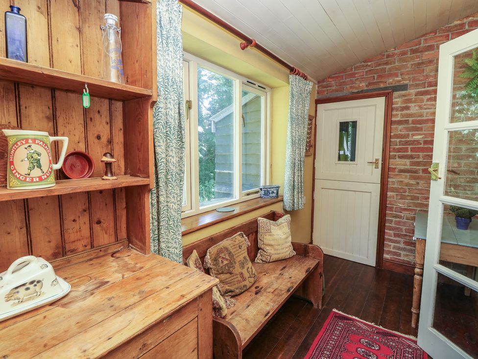 A sunroom with a bench and shelf at Guildford Farmhouse in Ryde
