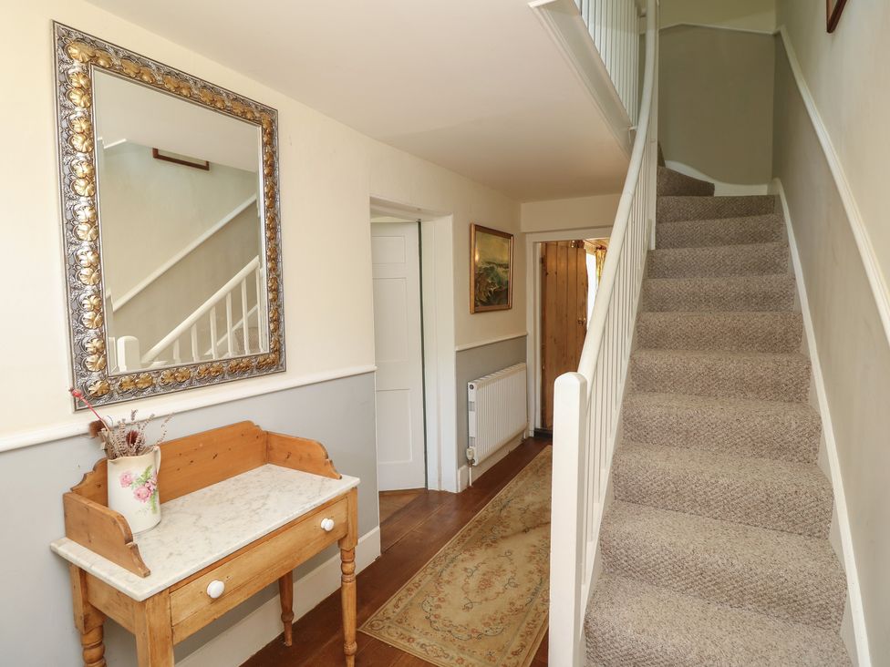 A hallway with a mirror and bench in Guildford Farmhouse in Ryde