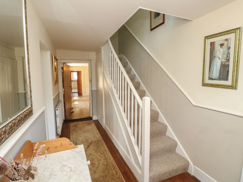 A hallway showcasing a staircase and decorative items at Guildford Farmhouse in Ryde