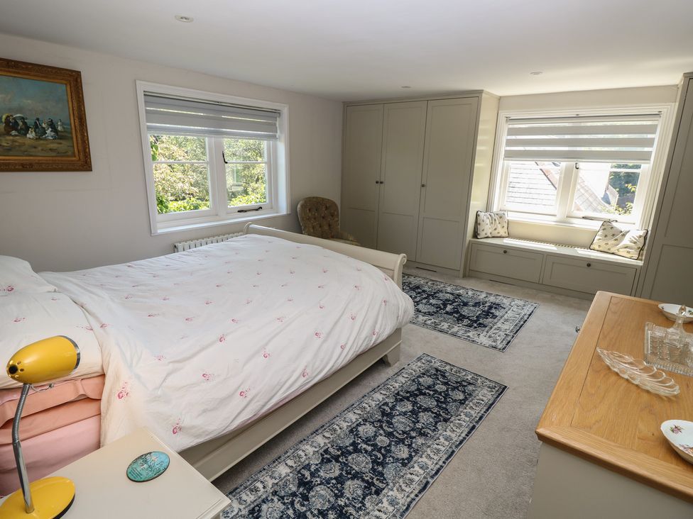 A bedroom with a bed and wardrobe at Guildford Farmhouse in Ryde
