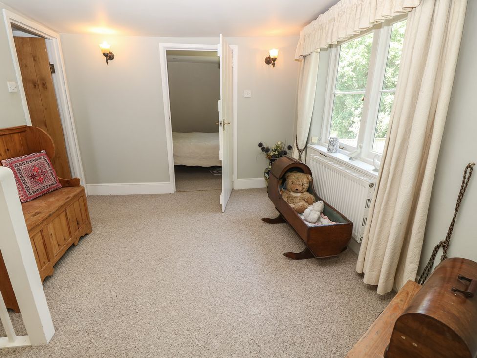 A hallway with a bench and teddy bear at Guildford Farmhouse in Ryde