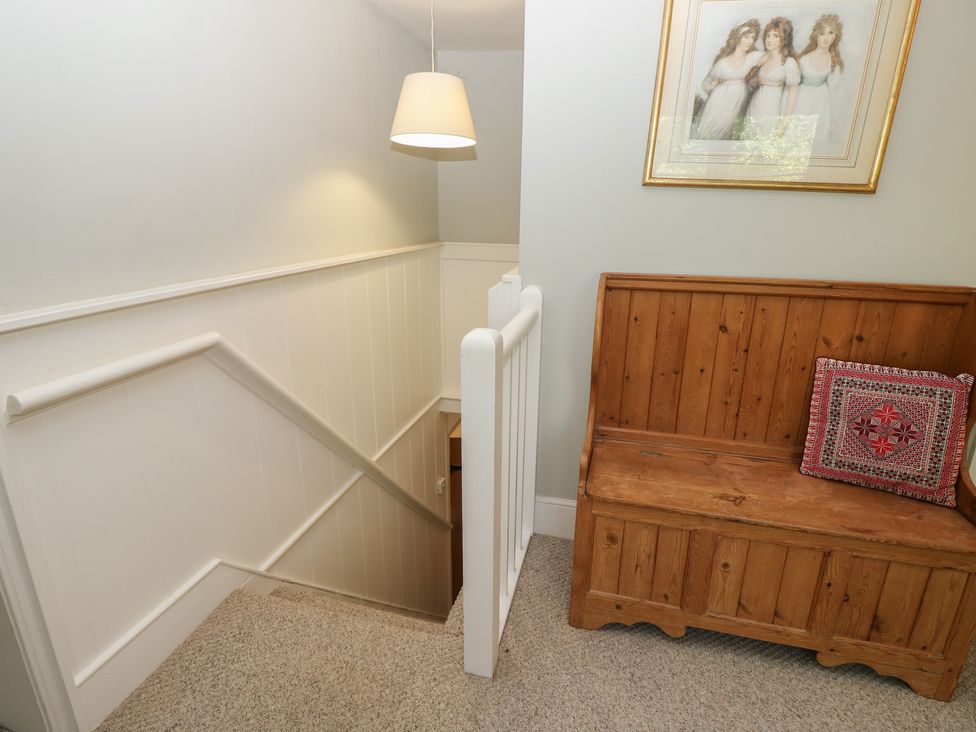 A staircase with a bench and a painting at Guildford Farmhouse in Ryde